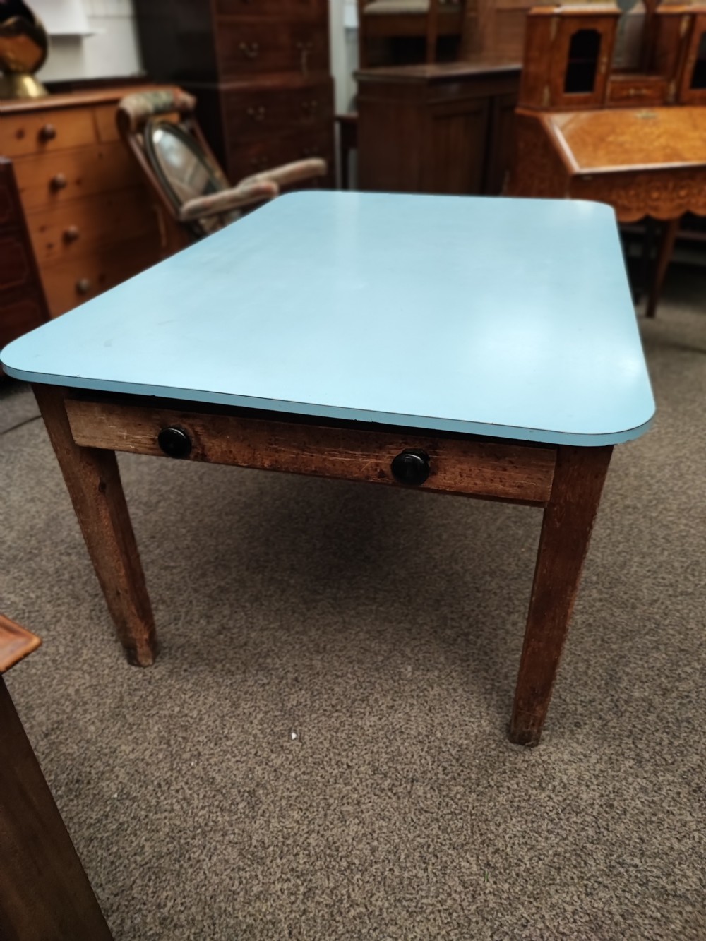 An antique pine kitchen table with duck egg blue Formica top.