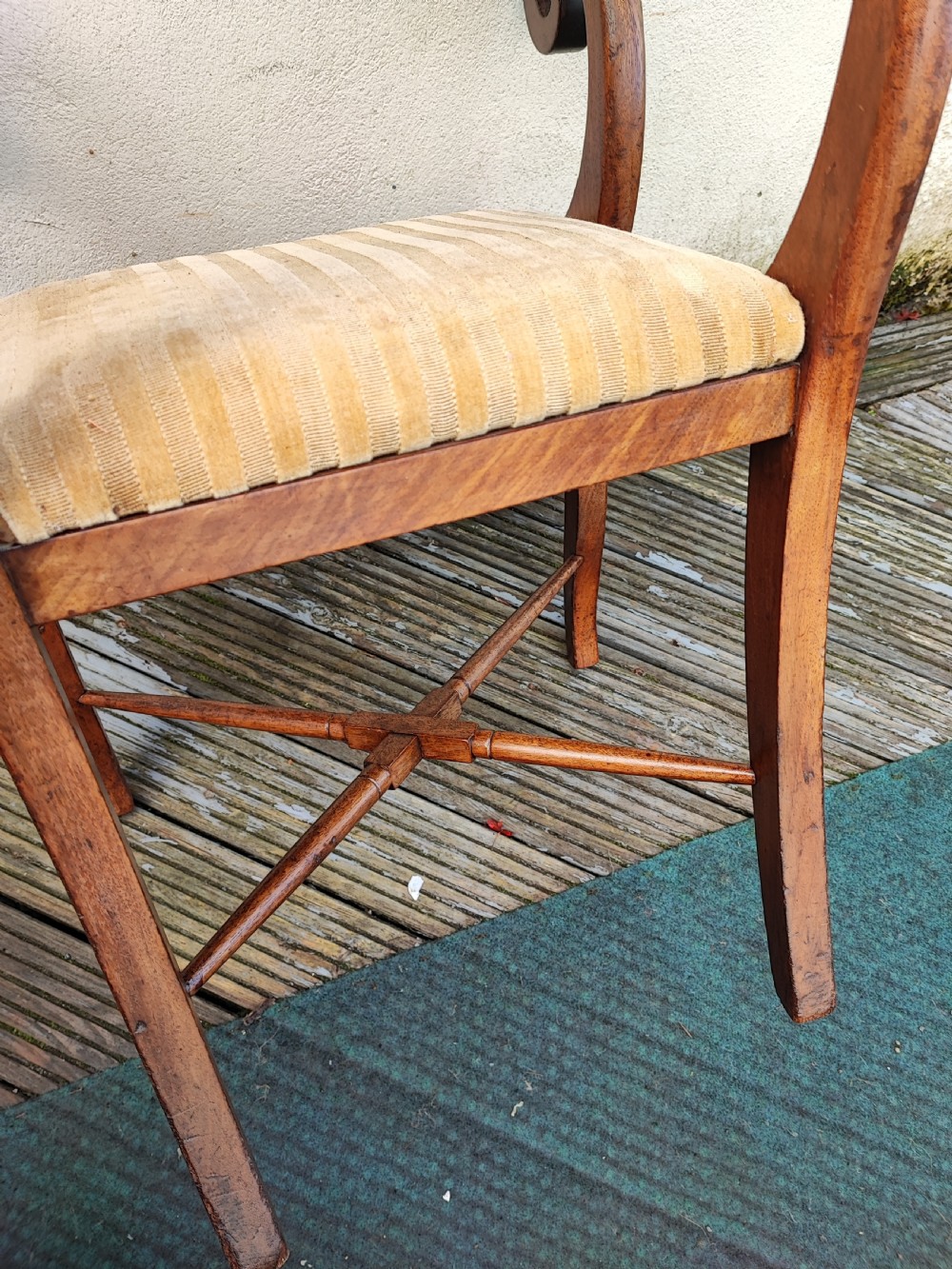 A Regency mahogany armchair featuring curved scroll arms, sabre legs, cross stretchers, and a yellow striped fabric seat. View V