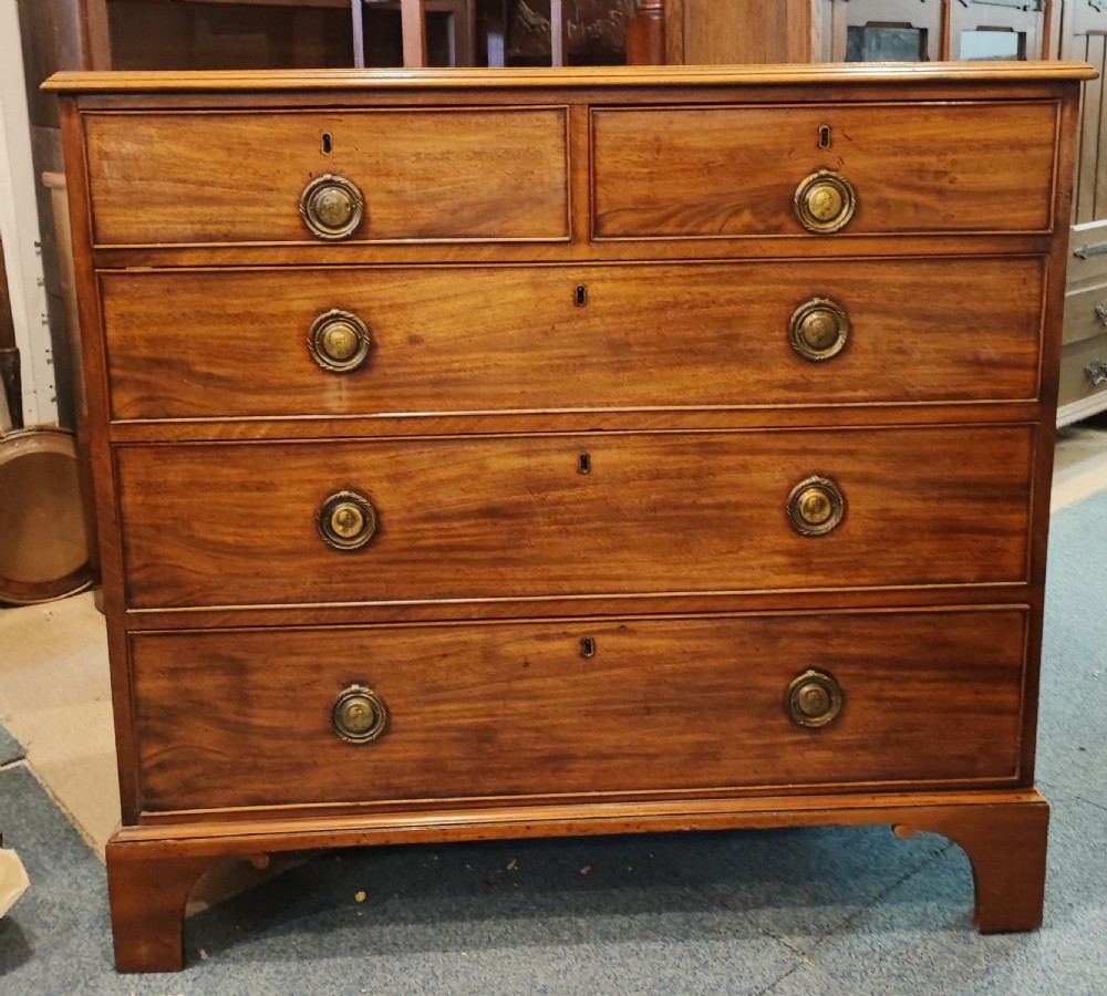 A rare Georgian mahogany chest of drawers,with original handles depicts the profile of King George III.