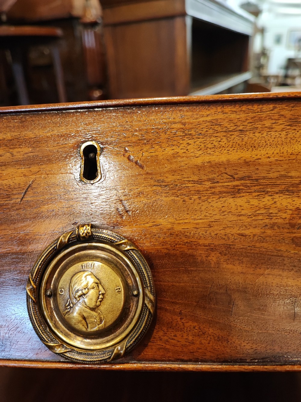 A rare Georgian mahogany chest of drawers,with original handles depicts the profile of King George III. View IV