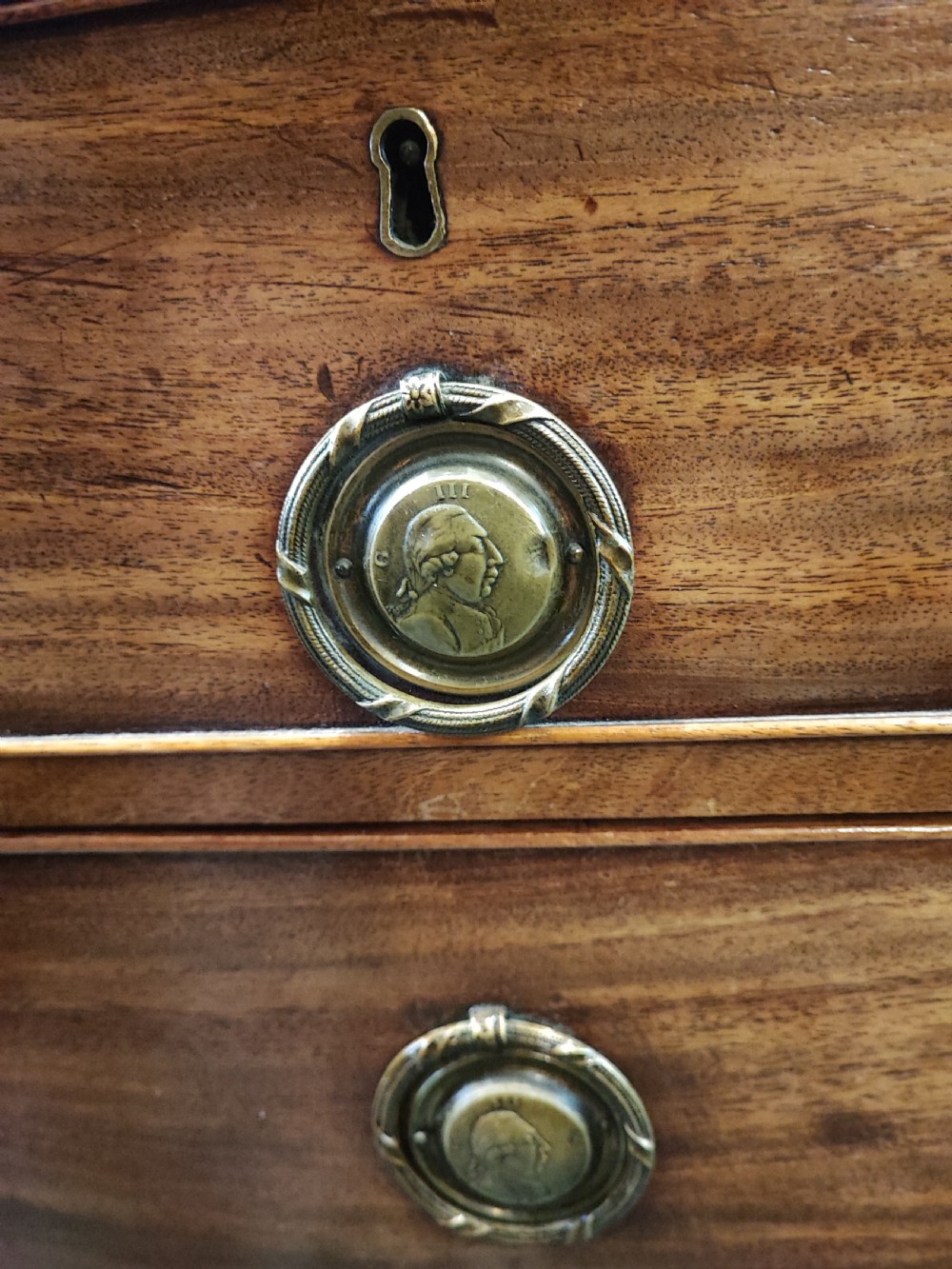 A rare Georgian mahogany chest of drawers,with original handles depicts the profile of King George III. View XIV