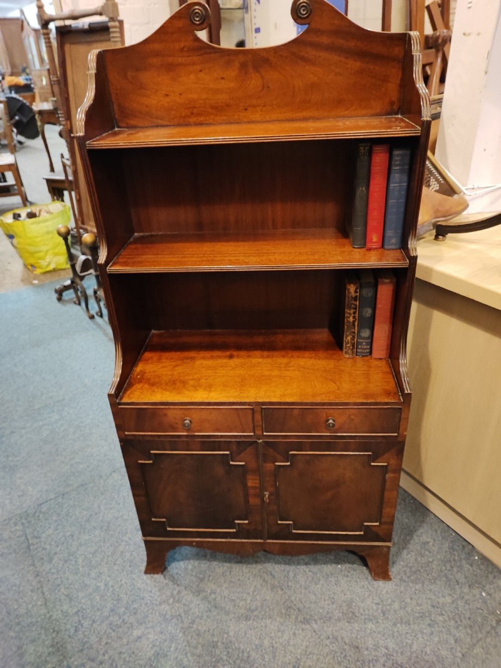 Antique mahogany waterfall open bookcase in the Regency revival style.
