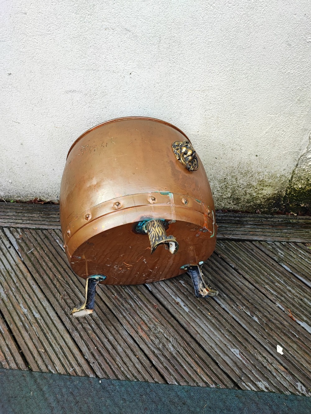 A deep cylindrical copper log bin featuring riveted side seams, brass lion-mask drop-ring handles, and raised paw feet. View IX