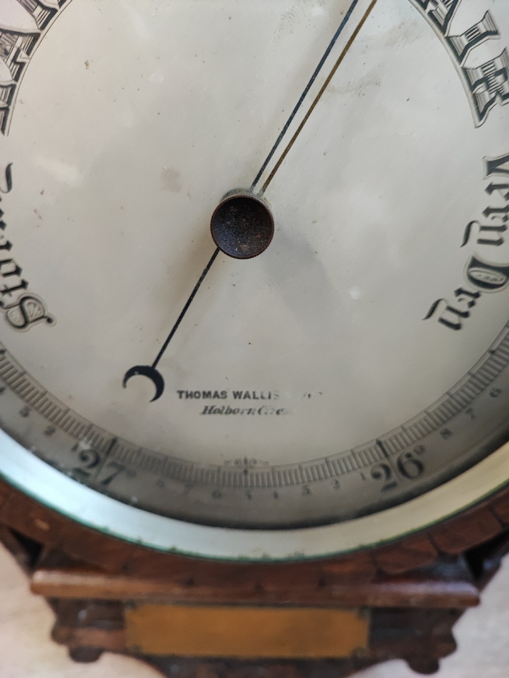 A carved oak wall barometer featuring an upper thermometer flanked by turned columns above a circular aneroid dial. View V