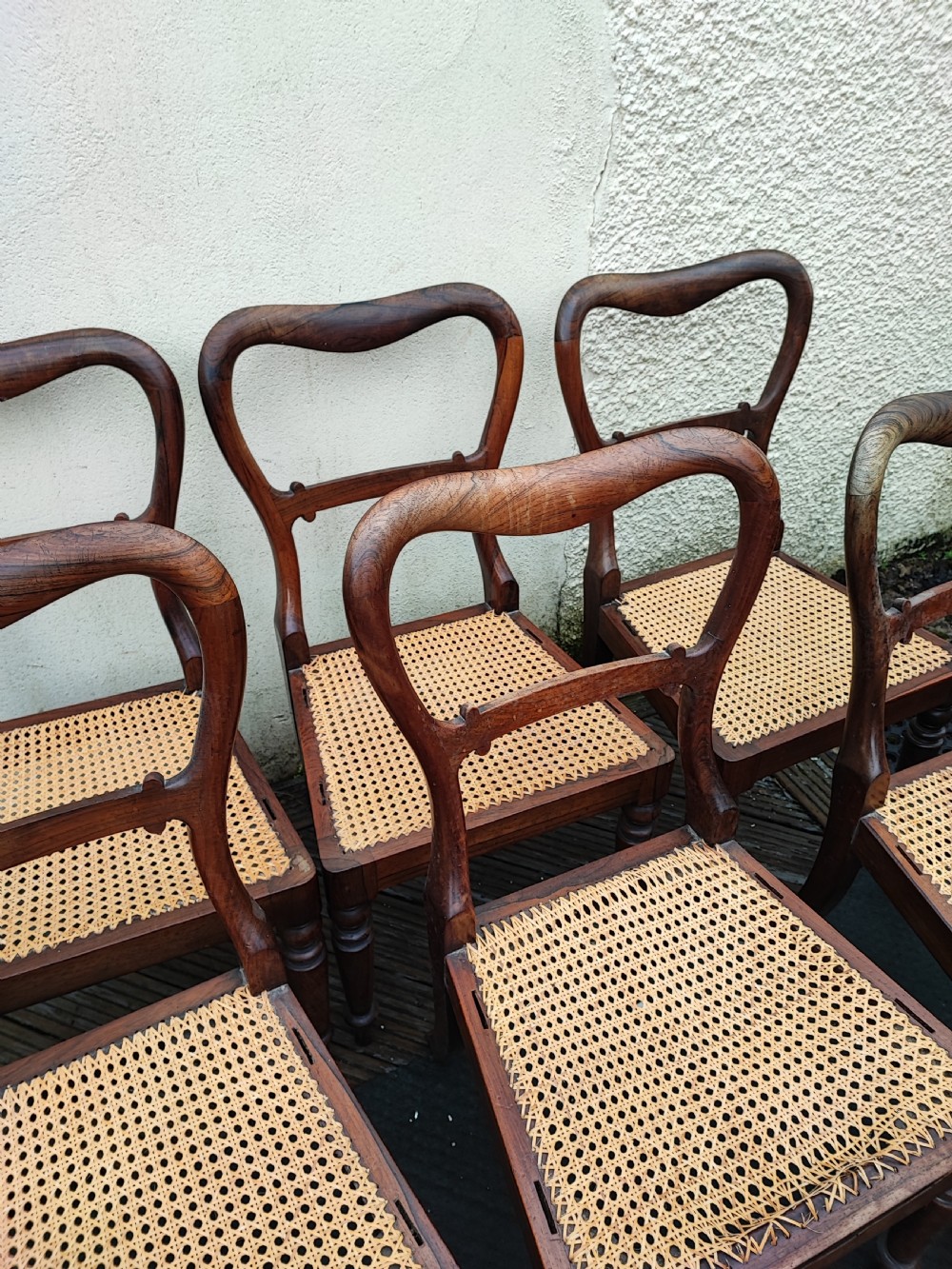 A set of six Regency rosewood dining chairs featuring swept open backrests, turned front legs, and woven natural cane seats. View IV