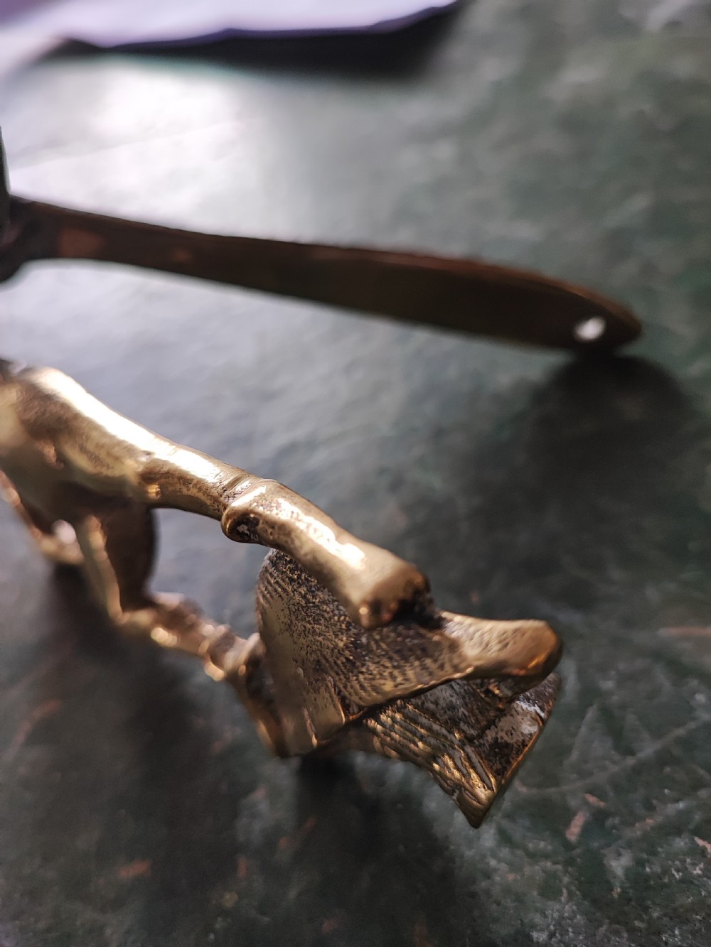 An antique solid brass door knocker sculpted in the shape of a whimsical imp holding a lantern while standing atop a mushroom base. View XI