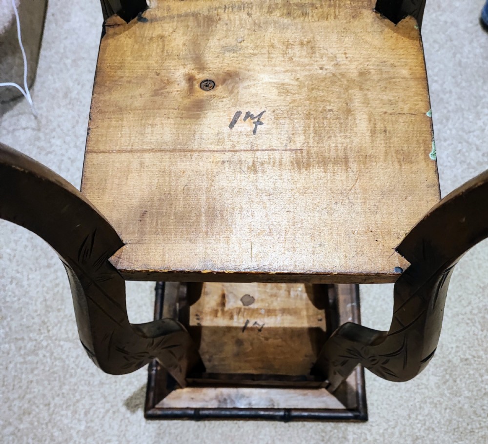 A square Arts and Crafts wooden side table featuring carved iris botanical motifs, bamboo-style edge moulding, shaped legs, and a carved lower shelf. View II