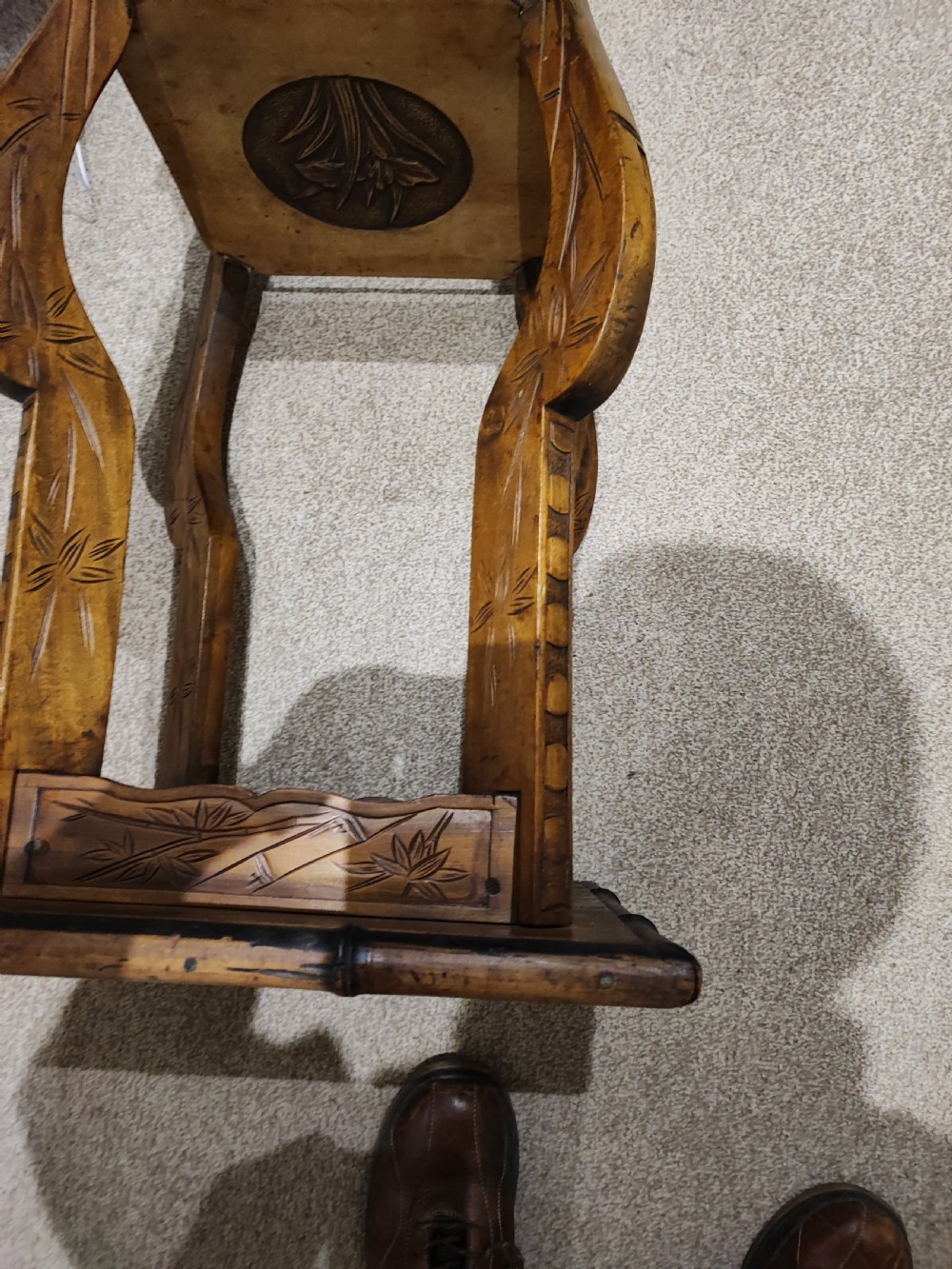 A square Arts and Crafts wooden side table featuring carved iris botanical motifs, bamboo-style edge moulding, shaped legs, and a carved lower shelf. View V