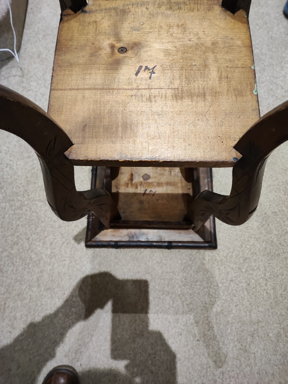 A square Arts and Crafts wooden side table featuring carved iris botanical motifs, bamboo-style edge moulding, shaped legs, and a carved lower shelf. View X