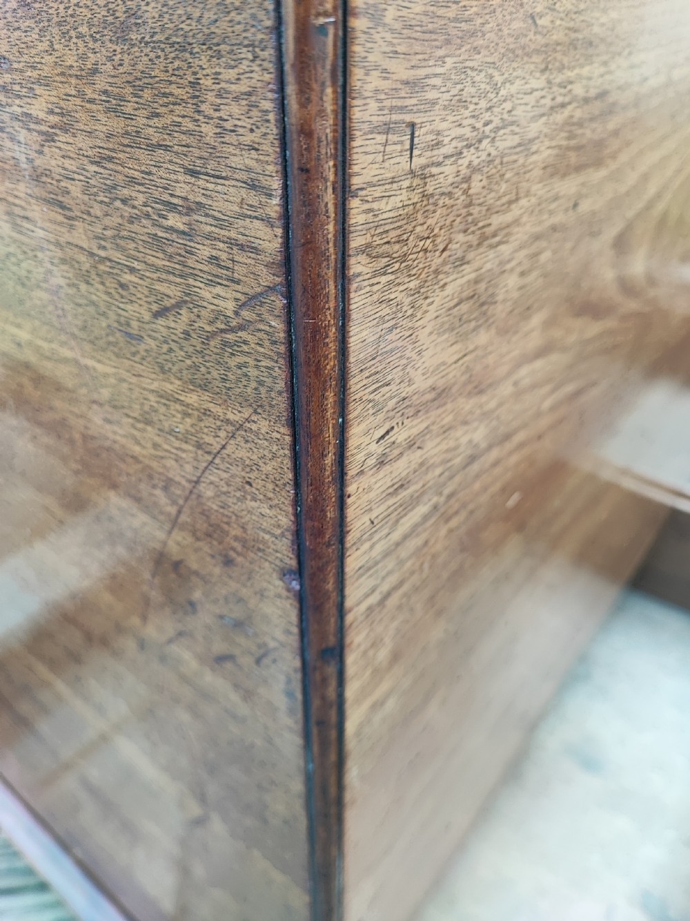 A George III mahogany storage trunk featuring a hinged top lid, two lower drawers, and brass batwing escutcheon handles. View V