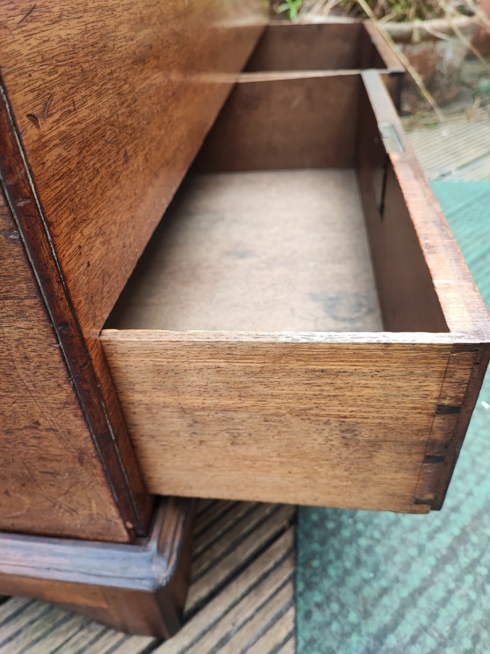 A George III mahogany storage trunk featuring a hinged top lid, two lower drawers, and brass batwing escutcheon handles. View VI