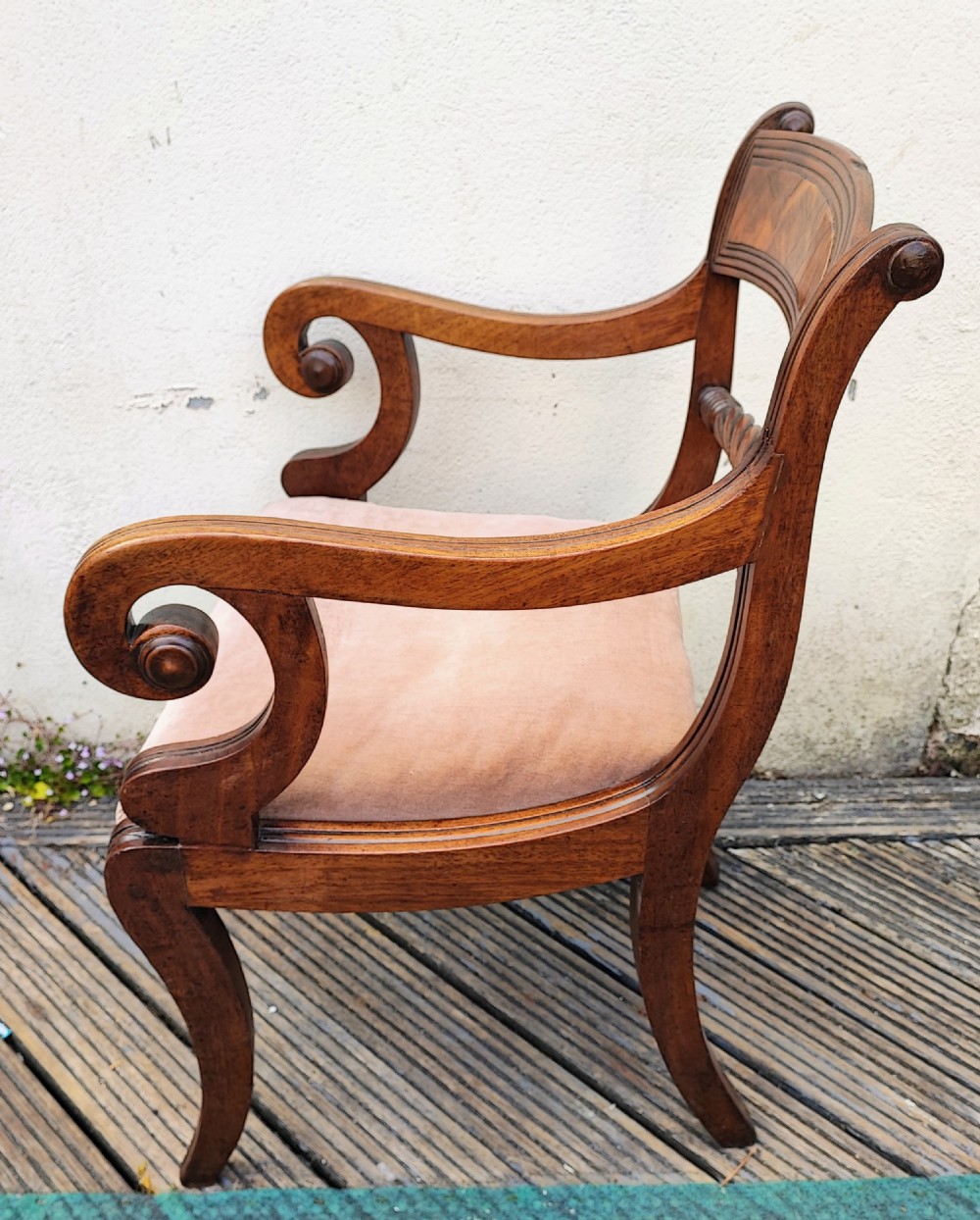 A side view of a Regency period mahogany armchair featuring carved scroll arms, sabre legs, and a padded seat. View VI