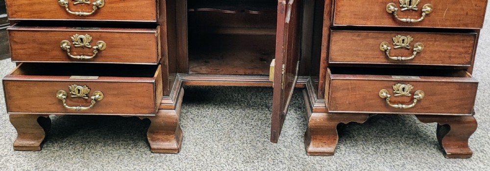 An eighteenth-century Georgian mahogany kneehole desk featuring a leather writing surface, multiple drawers with brass handles, a central recessed cupboard, and bracket feet. View III