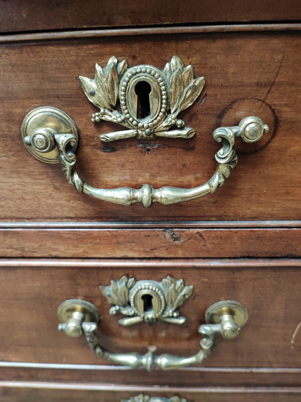 An eighteenth-century Georgian mahogany kneehole desk featuring a leather writing surface, multiple drawers with brass handles, a central recessed cupboard, and bracket feet. View VI