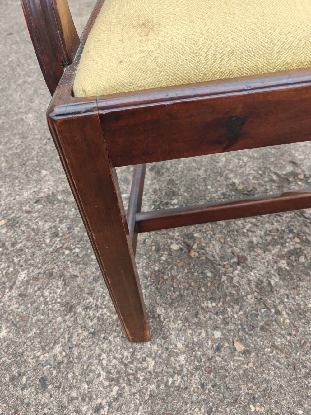 A Georgian mahogany carver armchair featuring a carved pierced back splat, swept arms, and a light yellow drop-in seat cushion. View III