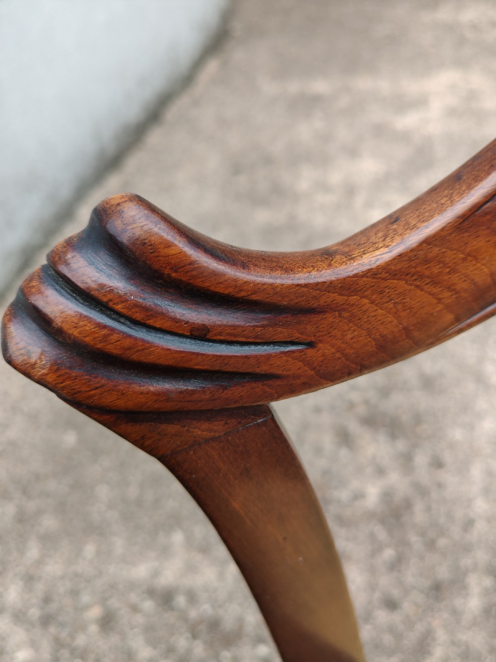 A Georgian mahogany carver armchair featuring a carved pierced back splat, swept arms, and a light yellow drop-in seat cushion. View VI