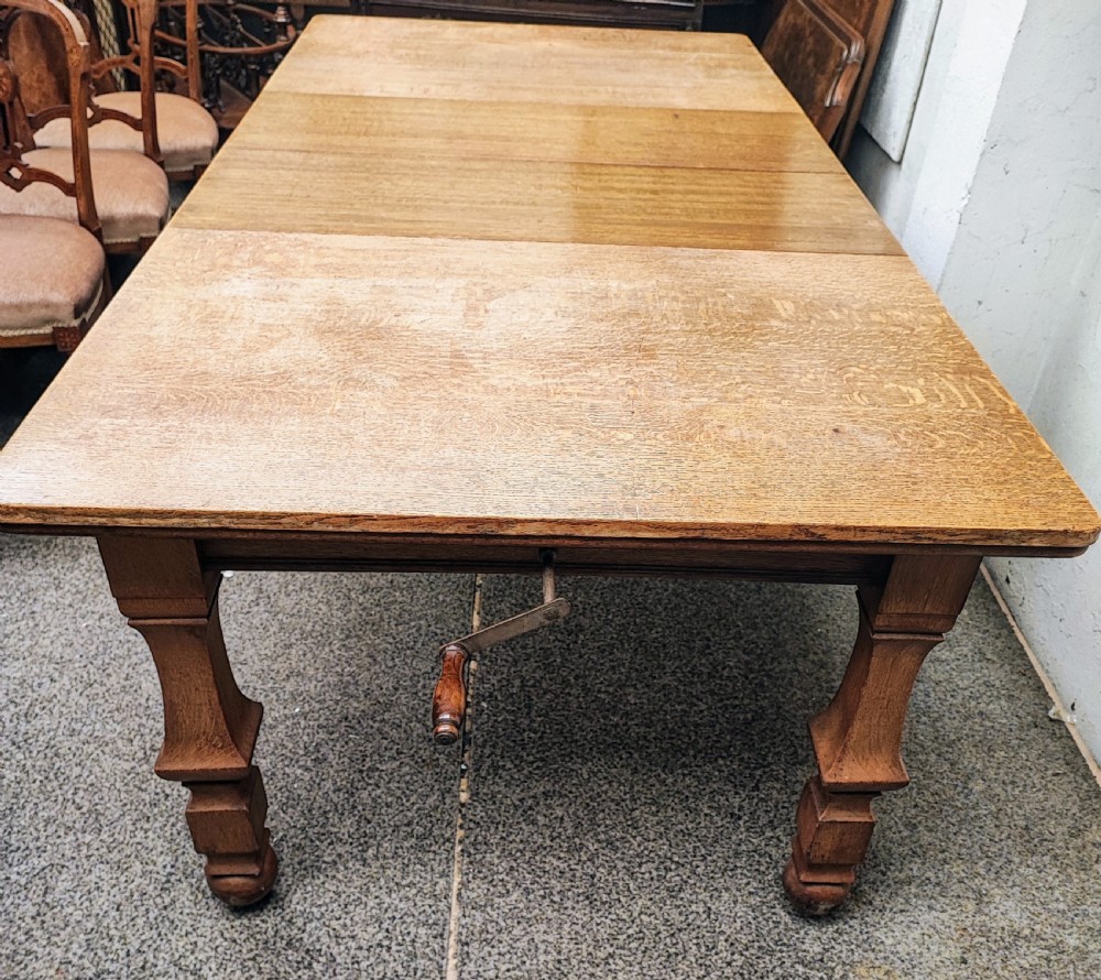 Antique golden oak 2 leaf extending dining table.