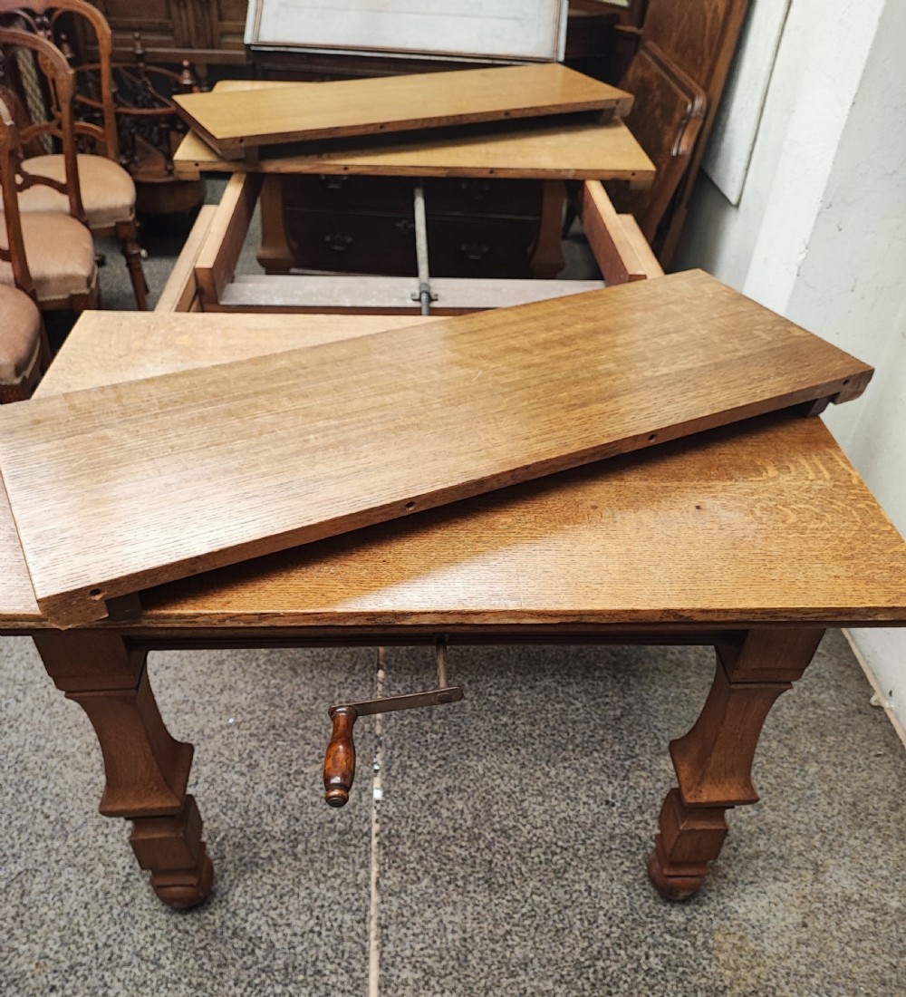 Antique golden oak 2 leaf extending dining table. View XV