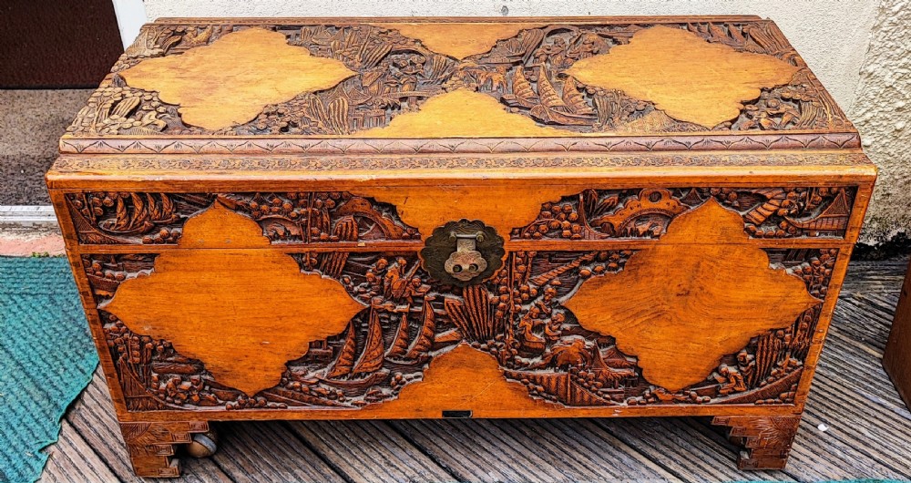 Striking antique carved teak and camphor trunk.