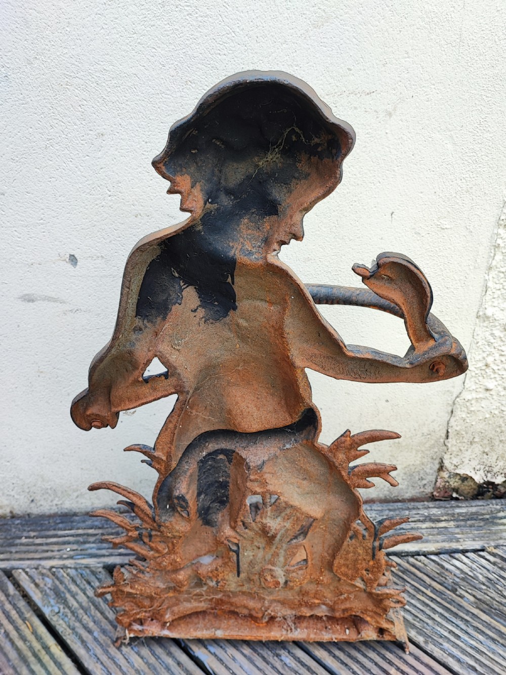 A Victorian cast iron stick stand featuring a figure of a young boy holding a serpent on a leafy base with an integrated drip tray. View IV