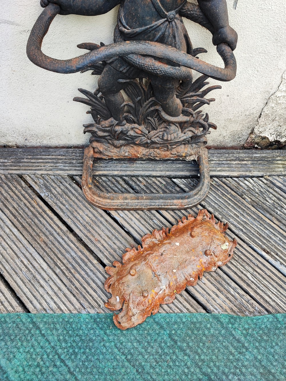 A Victorian cast iron stick stand featuring a figure of a young boy holding a serpent on a leafy base with an integrated drip tray. View V