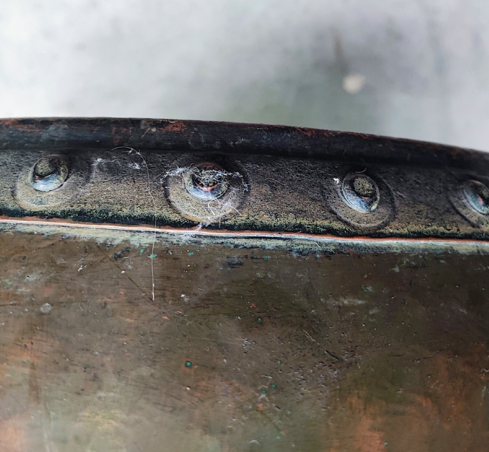 A large, rounded Arts and Crafts copper vessel featuring a hand-hammered shoulder, riveted metal band, and dual side handles. View IV