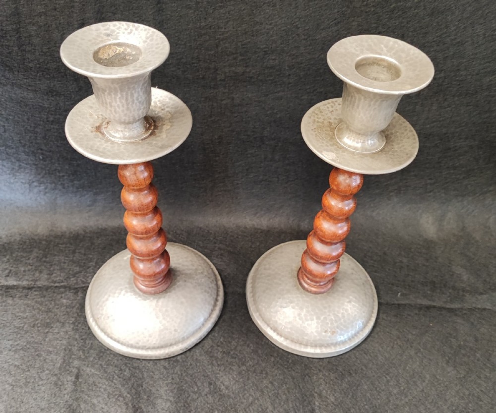 A liberty's style pair of pewter and oak candlesticks.