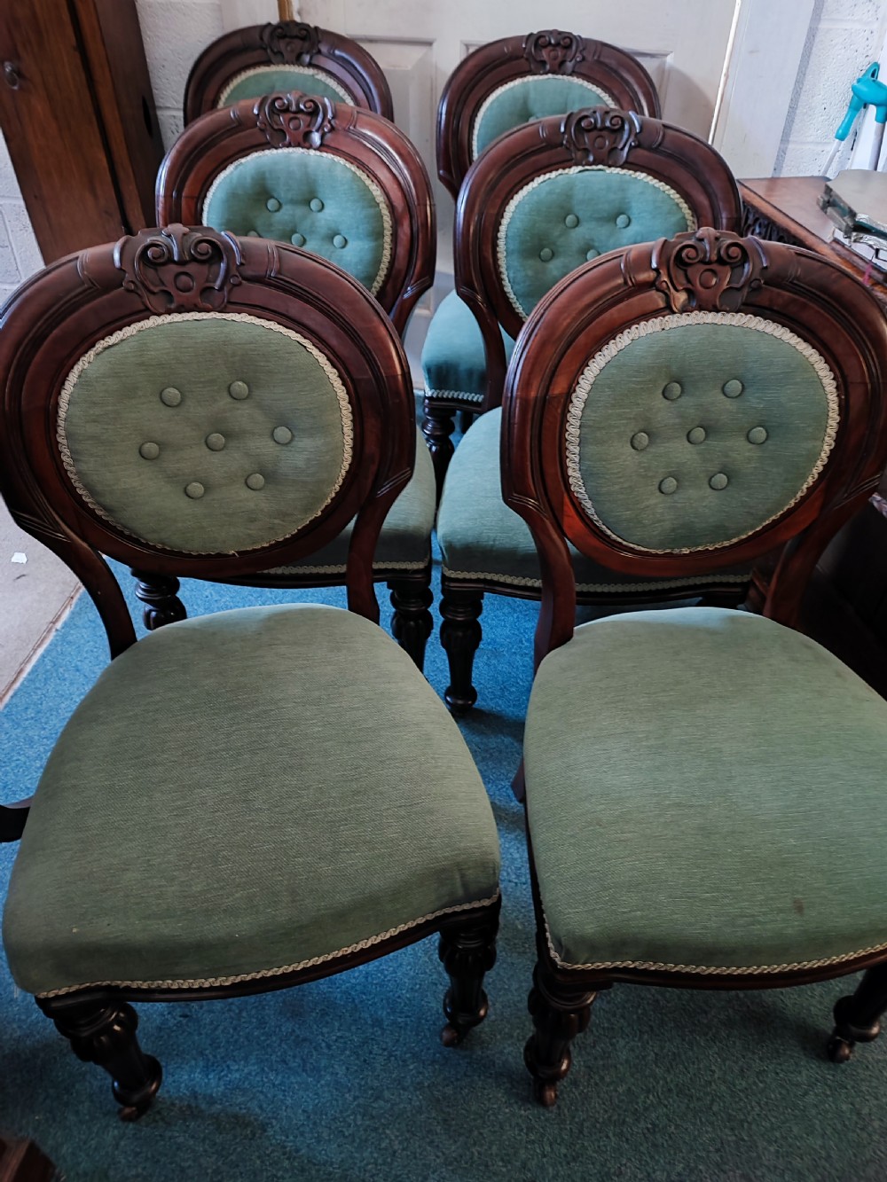 A set of six Victorian mahogany dining chairs featuring carved balloon backs, green buttoned upholstery, and turned front legs. View II