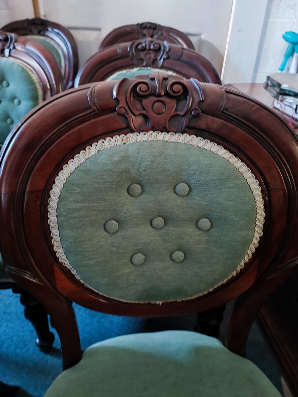 A set of six Victorian mahogany dining chairs featuring carved balloon backs, green buttoned upholstery, and turned front legs. View III
