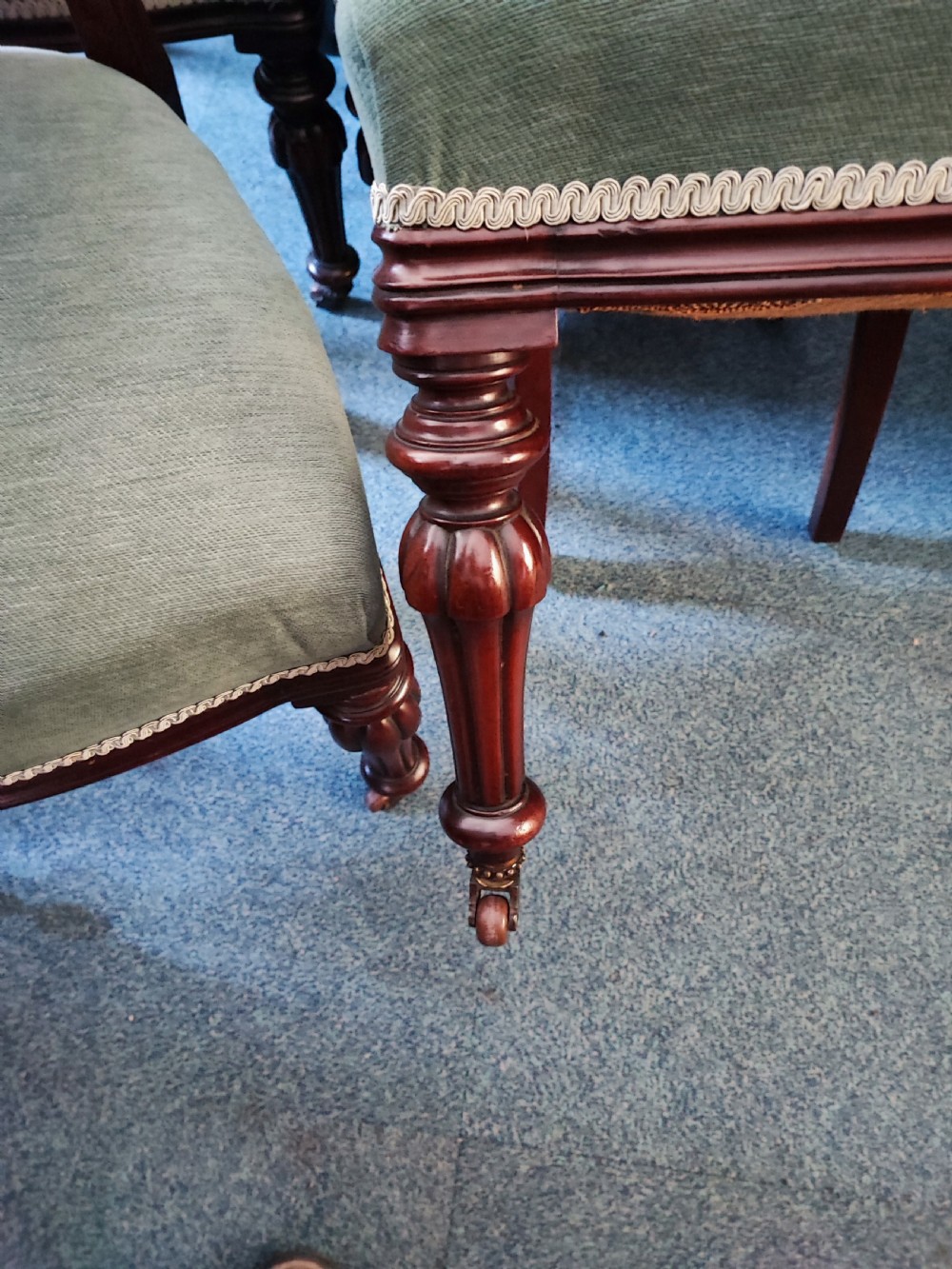 A set of six Victorian mahogany dining chairs featuring carved balloon backs, green buttoned upholstery, and turned front legs. View IX