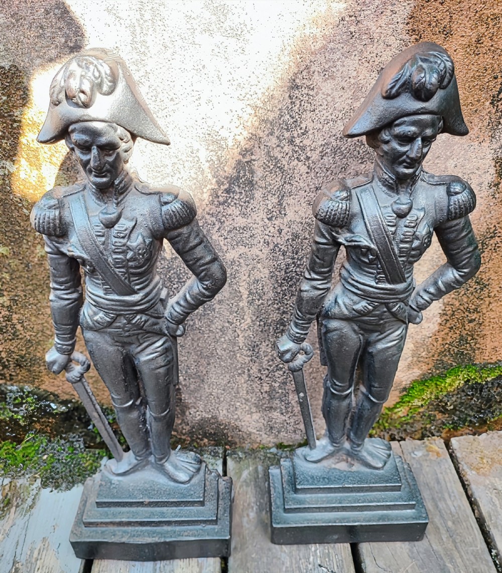 A pair of cast iron Victorian doorstops depicted as military officers in full uniform standing on stepped bases.