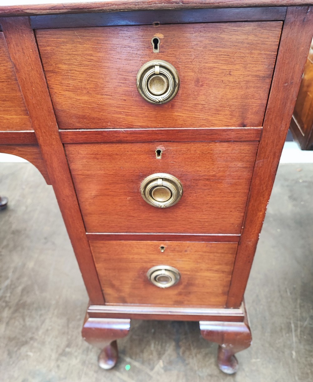 An Edwardian mahogany kneehole writing desk featuring a green leather inset top, brass ring handles, and cabriole legs. View III