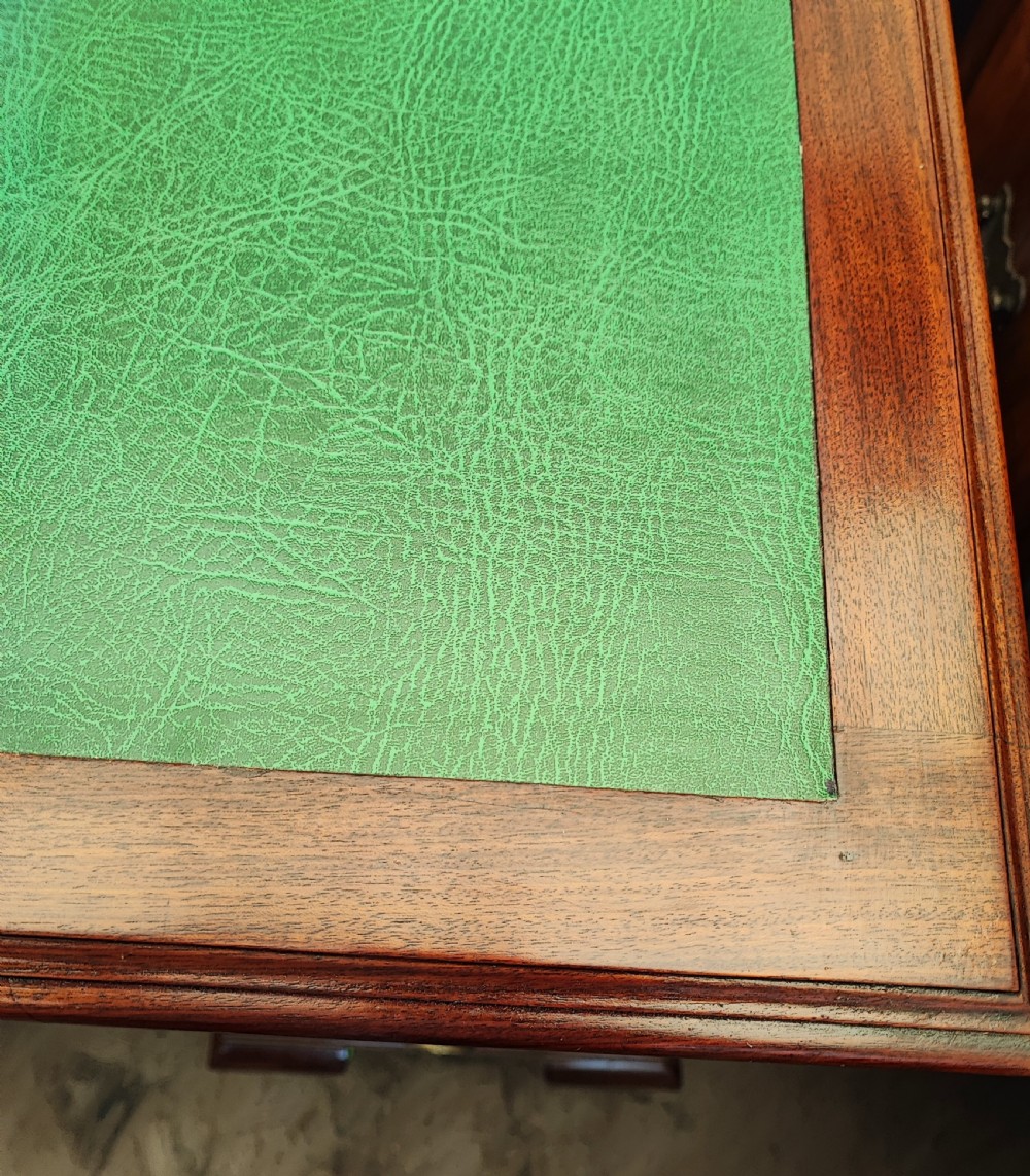 An Edwardian mahogany kneehole writing desk featuring a green leather inset top, brass ring handles, and cabriole legs. View IV
