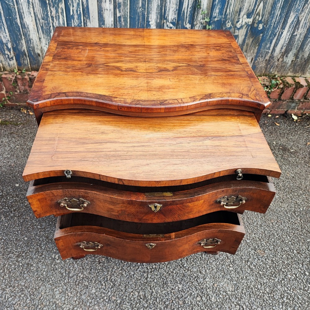 A quality serpentine walnut chest of drawers View II