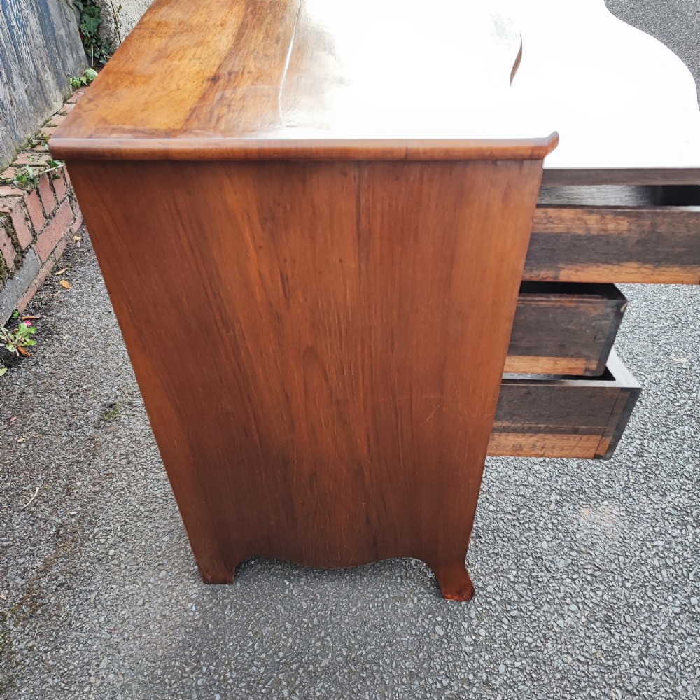 A quality serpentine walnut chest of drawers View III