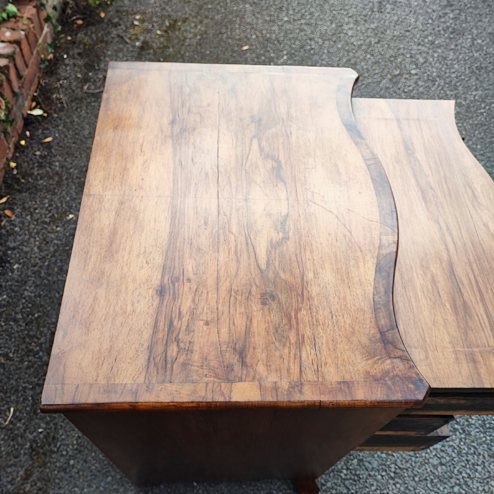 A quality serpentine walnut chest of drawers View V