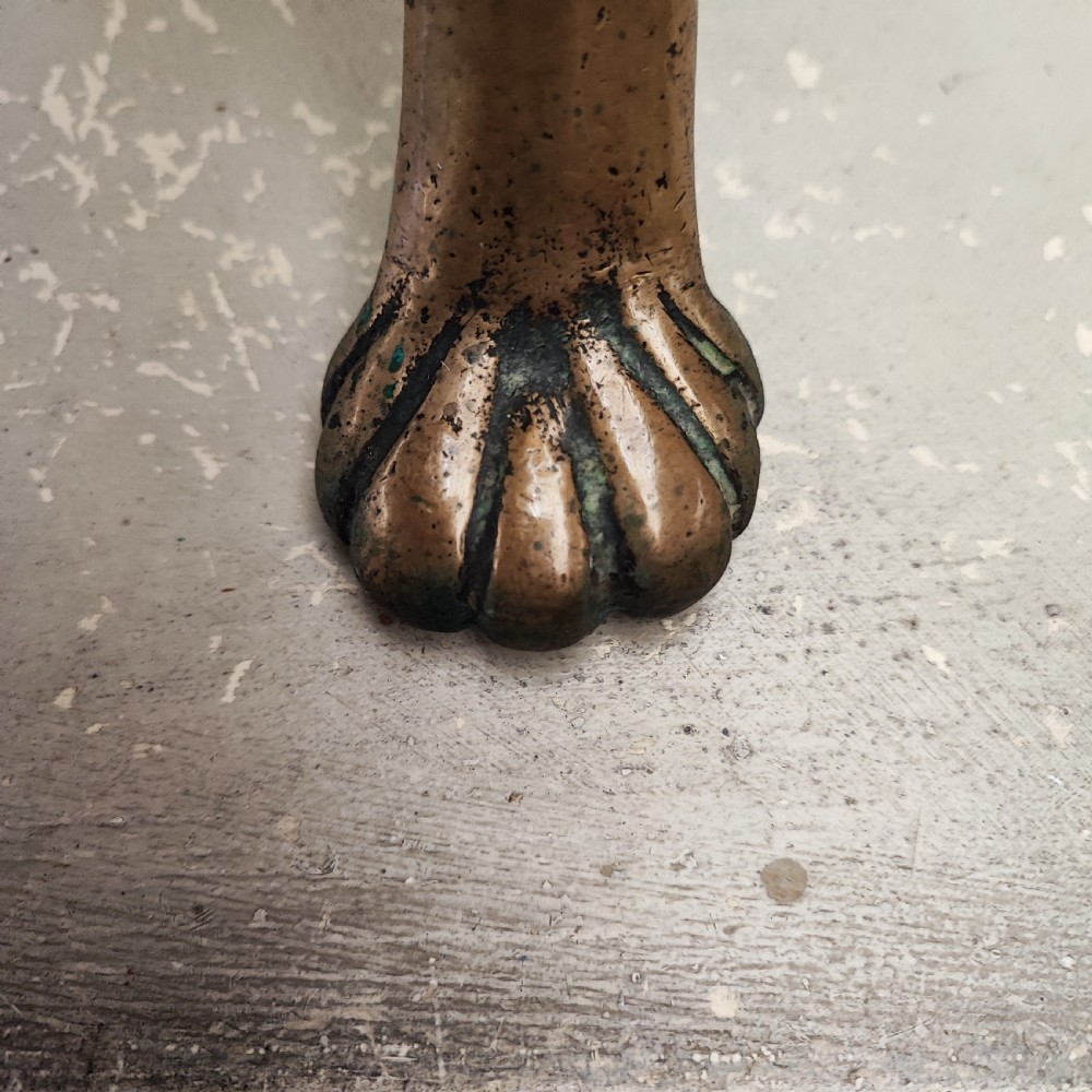 A Georgian brass hearth footman featuring a smooth rectangular top, side drop handles, a scalloped apron, and front cabriole legs with paw feet. View II