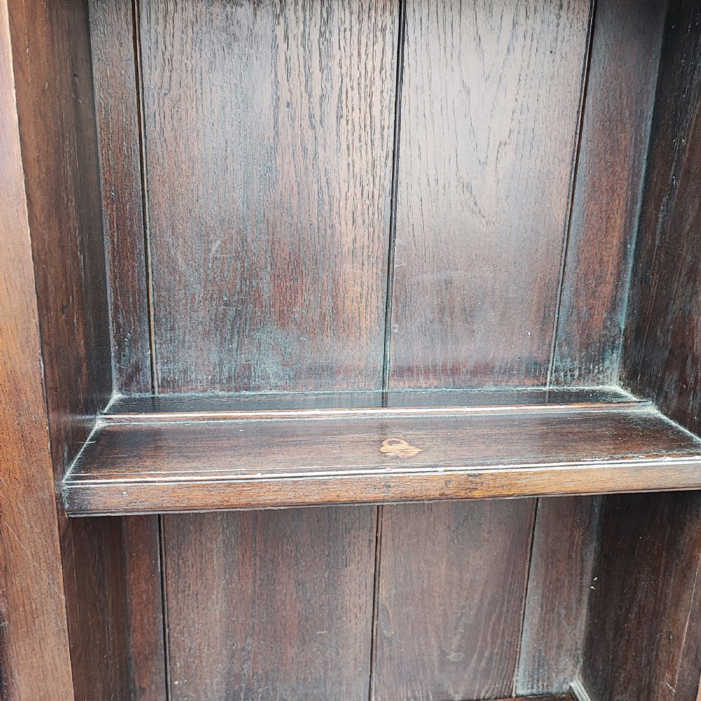 An antique dark oak small dresser featuring an open shelving unit with side cupboards over a two-drawer base raised on cabriole legs. View V