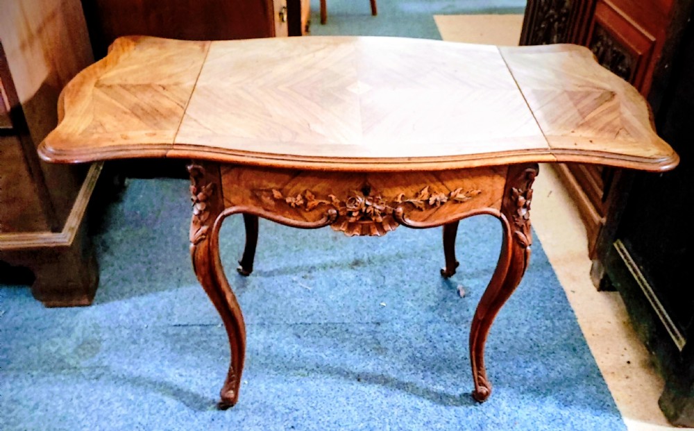 An antique French rosewood side table featuring a parquetry top with extendable side leaves, carved floral apron details, and slender cabriole legs. View VIII