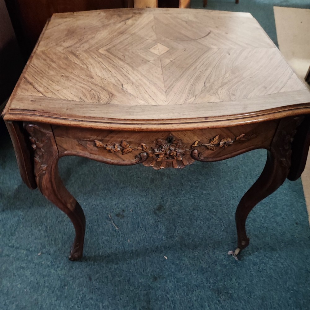 An antique French rosewood side table featuring a parquetry top with extendable side leaves, carved floral apron details, and slender cabriole legs. View X