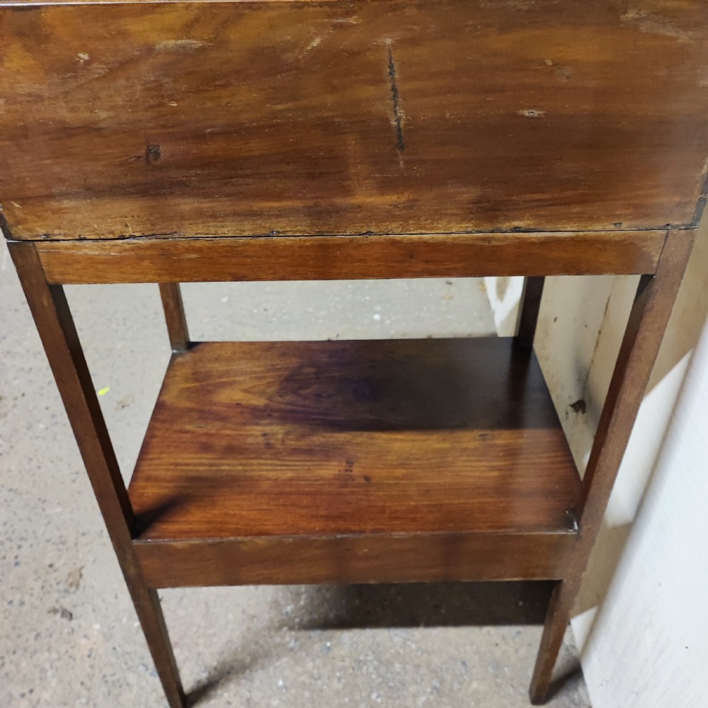 A Georgian mahogany bedside table featuring a high gallery tray top, an open middle shelf, a single drawer with brass knobs, and straight legs. View V