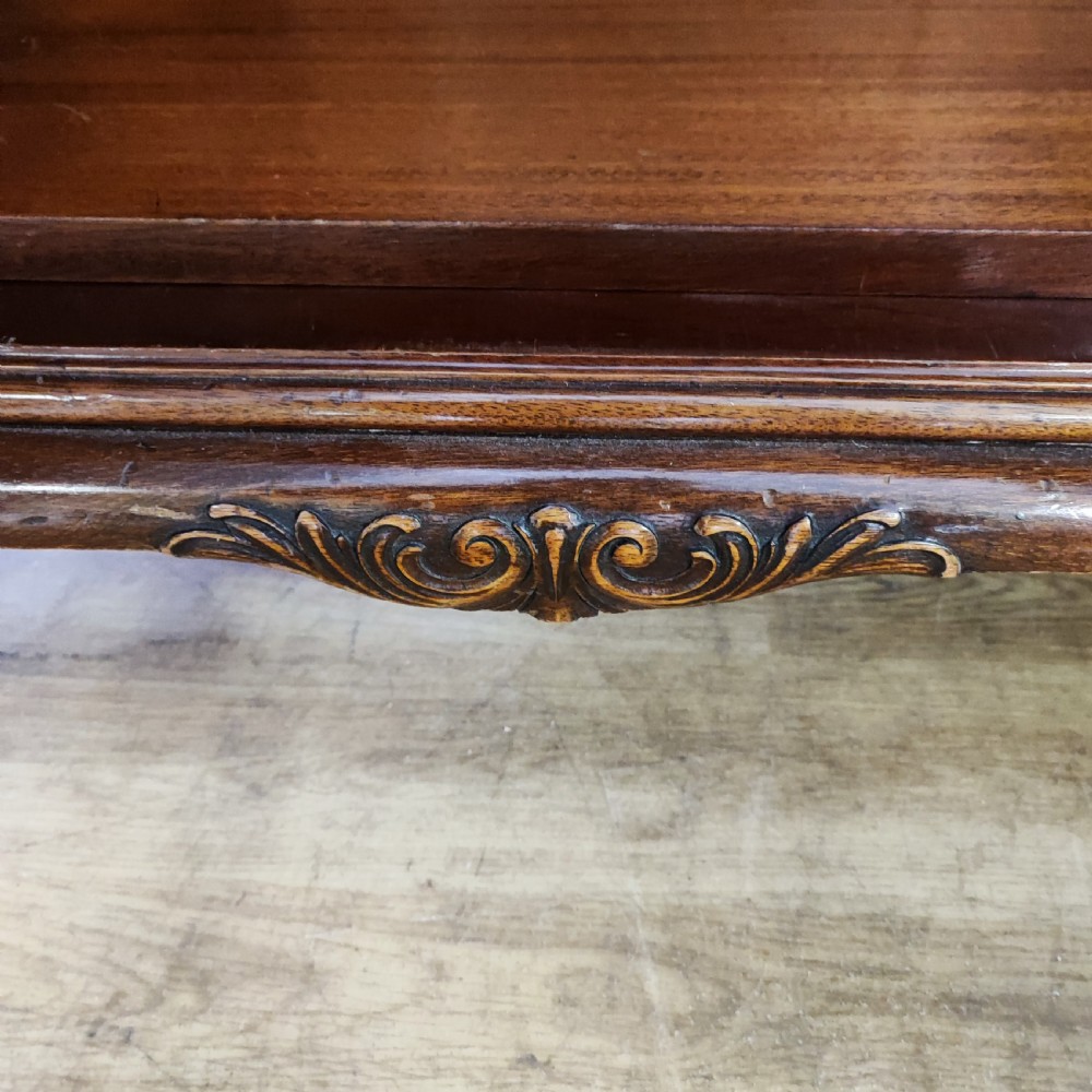 An Edwardian flame mahogany three-door wardrobe featuring carved rope twist moulding and carved bracket feet. View II