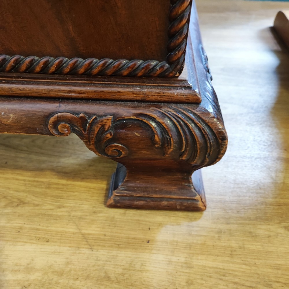 An Edwardian flame mahogany three-door wardrobe featuring carved rope twist moulding and carved bracket feet. View III