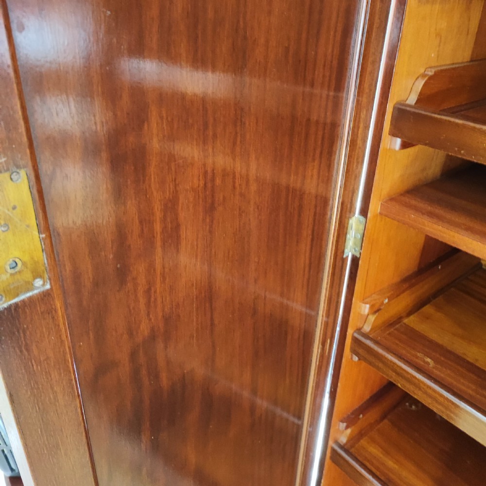 An Edwardian flame mahogany three-door wardrobe featuring carved rope twist moulding and carved bracket feet. View V