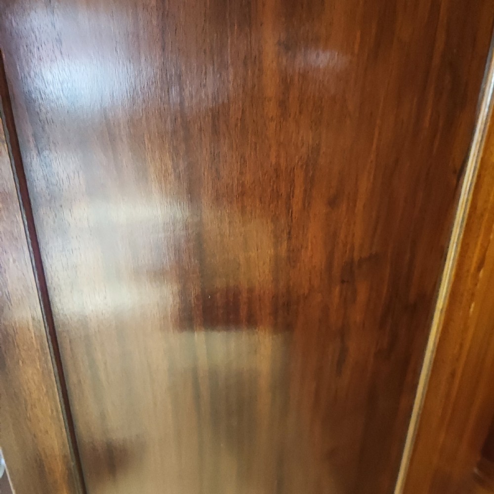 An Edwardian flame mahogany three-door wardrobe featuring carved rope twist moulding and carved bracket feet. View IX