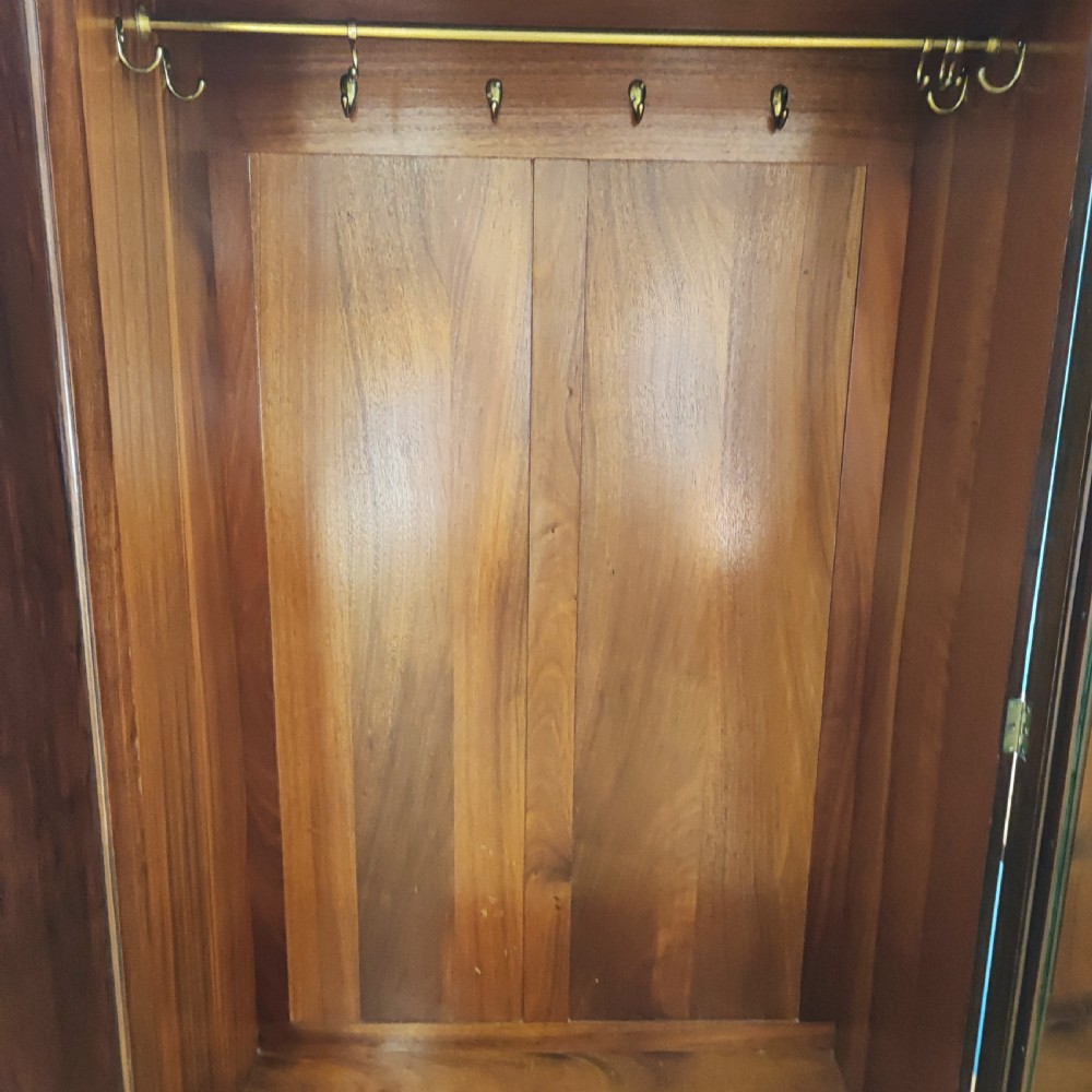 An Edwardian flame mahogany three-door wardrobe featuring carved rope twist moulding and carved bracket feet. View XI