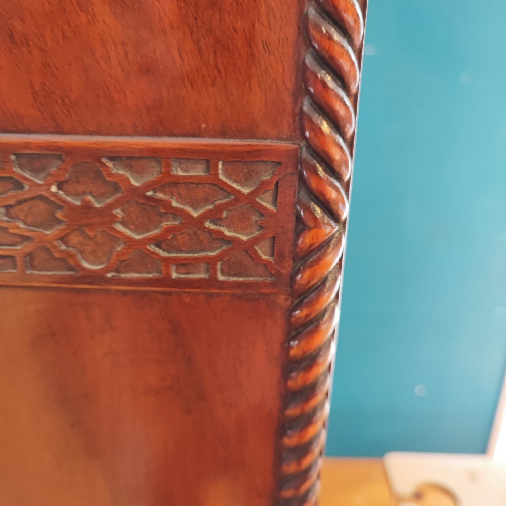 An Edwardian flame mahogany three-door wardrobe featuring carved rope twist moulding and carved bracket feet. View XII