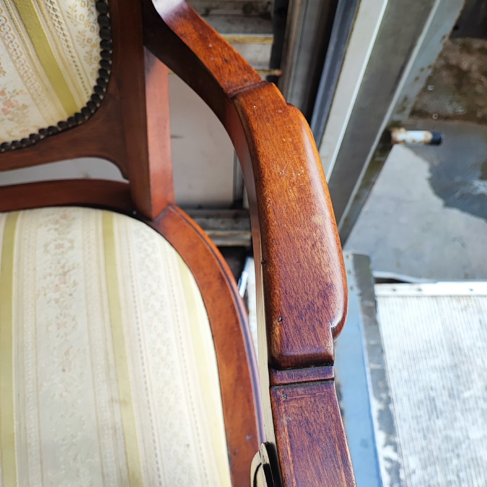 A pair of antique mahogany armchairs featuring cream and gold striped upholstery, curved cabriole legs, brass embellishments, and metal trim. View II