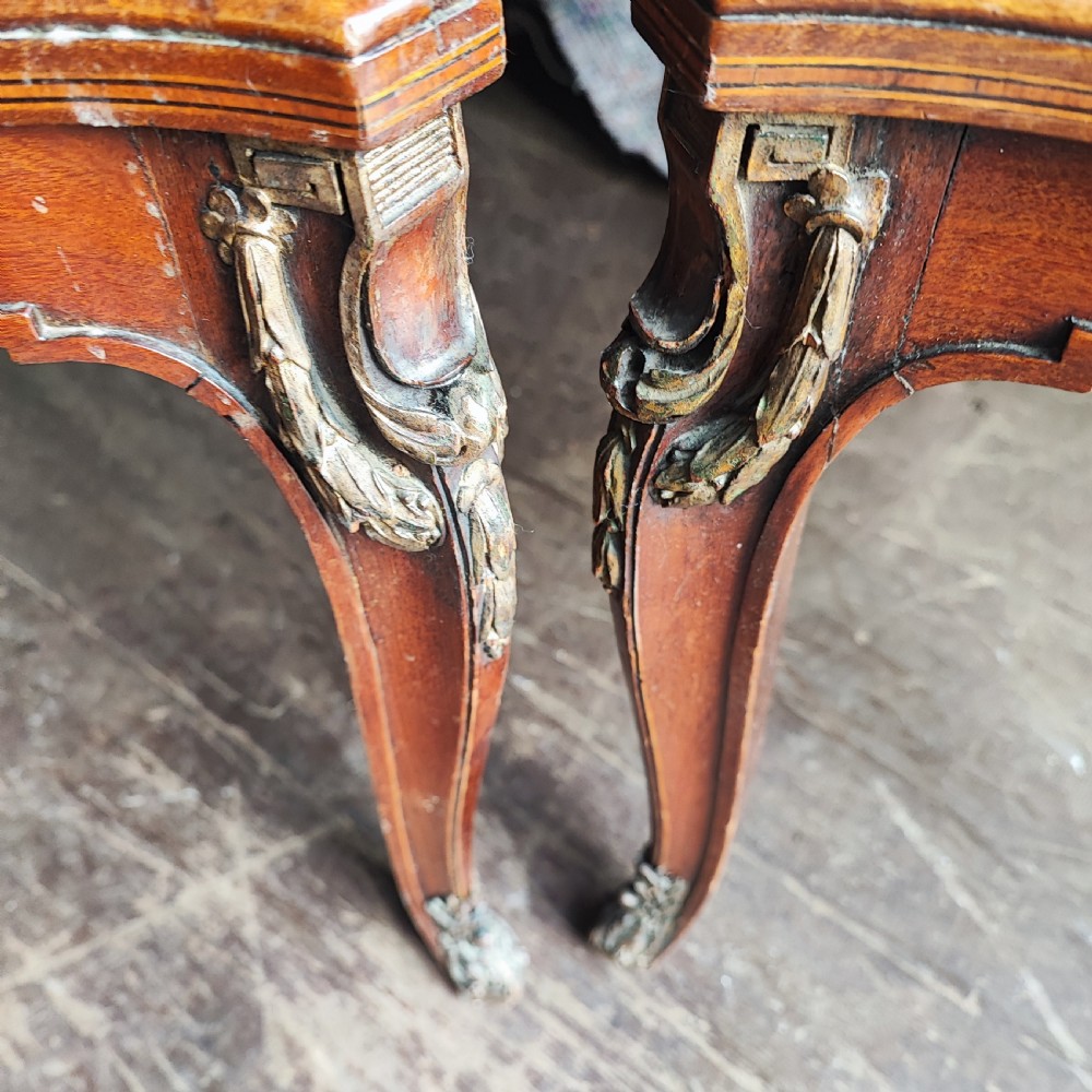 A pair of antique mahogany armchairs featuring cream and gold striped upholstery, curved cabriole legs, brass embellishments, and metal trim. View IV