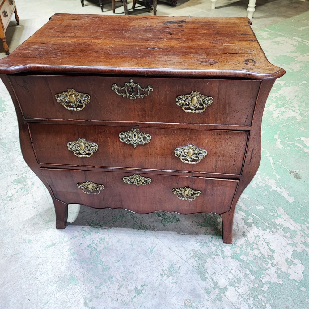 An eighteenth-century Dutch mahogany chest of drawers with a bombee front, three drawers, and cast brass handles.